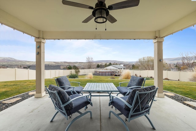 view of patio featuring ceiling fan and a mountain view