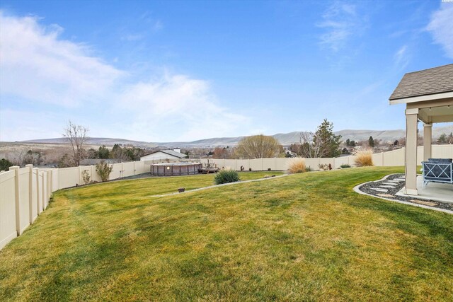 view of yard featuring a fenced in pool and a mountain view