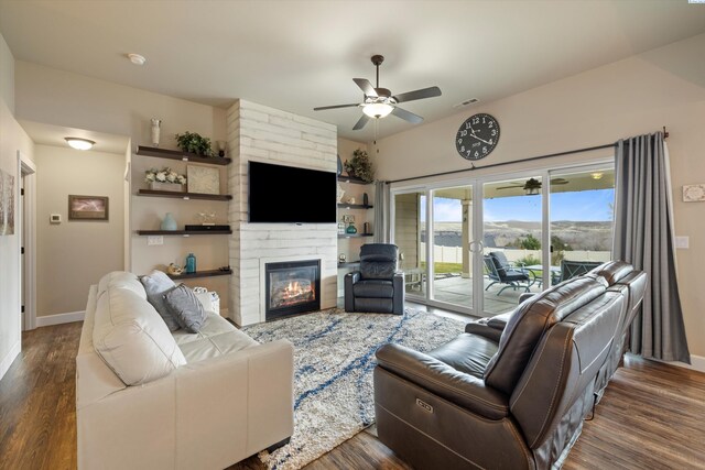 living room with dark wood-type flooring, a fireplace, and ceiling fan