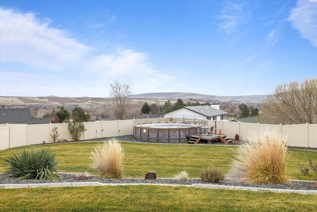 dock area featuring a pool side deck with mountain view and a lawn