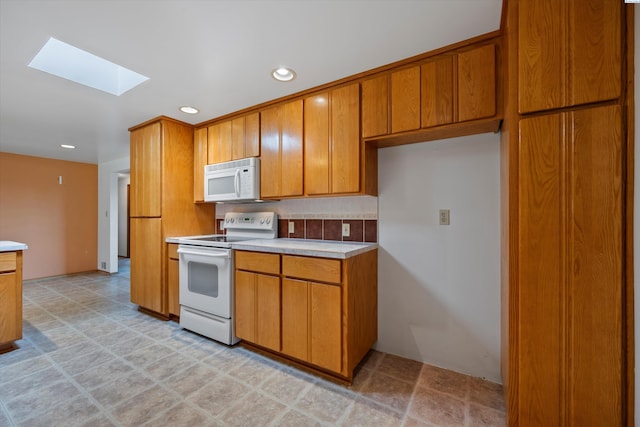 508 W Concord Ave, Grandview, WA 98930 - kitchen featuring white appliances, a skylight, brown cabinetry, light countertops, and recessed lighting