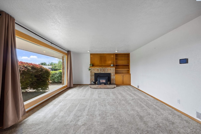 508 W Concord Ave, Grandview, WA 98930 - unfurnished living room featuring carpet flooring, a brick fireplace, a textured ceiling, and built in features