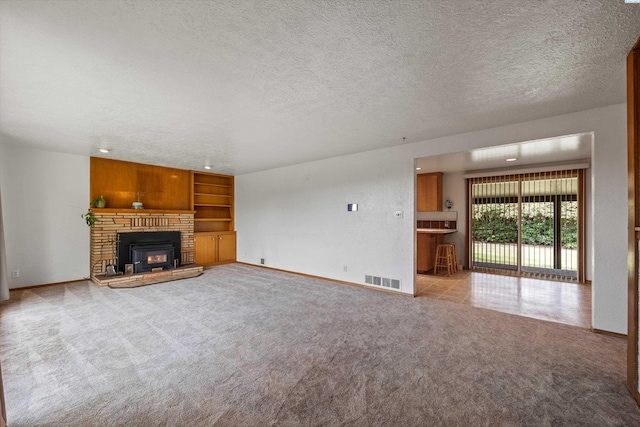 508 W Concord Ave, Grandview, WA 98930 - unfurnished living room featuring a textured ceiling, light colored carpet, and a glass covered fireplace