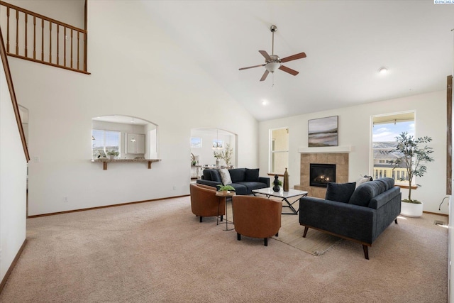 living room with arched walkways, carpet flooring, ceiling fan, and baseboards