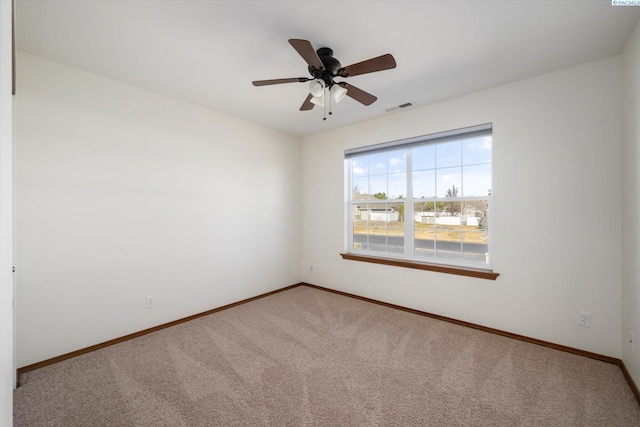 unfurnished room with carpet floors, baseboards, visible vents, and ceiling fan