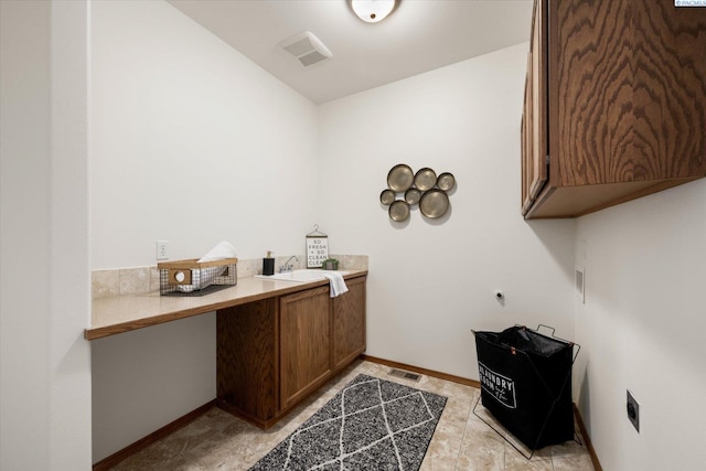 laundry area featuring cabinet space, visible vents, baseboards, electric dryer hookup, and a sink