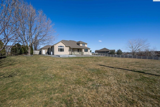 rear view of house with a yard and fence