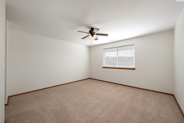 spare room featuring baseboards, a ceiling fan, and light colored carpet