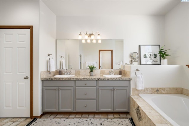 full bath featuring a sink, a bath, and double vanity