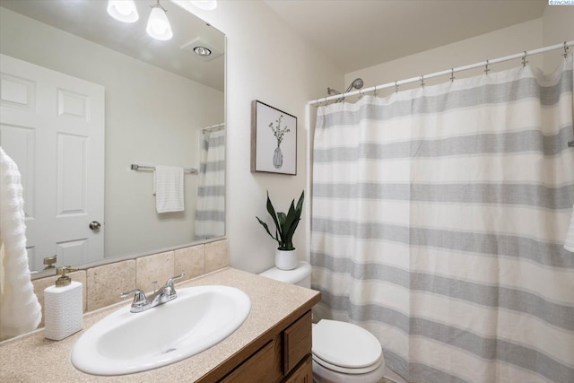 full bathroom featuring a shower with shower curtain, vanity, and toilet