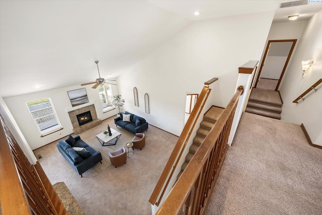 living area with lofted ceiling, stairway, and carpet