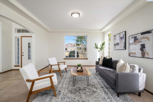 living room with arched walkways, tile patterned flooring, visible vents, and baseboards