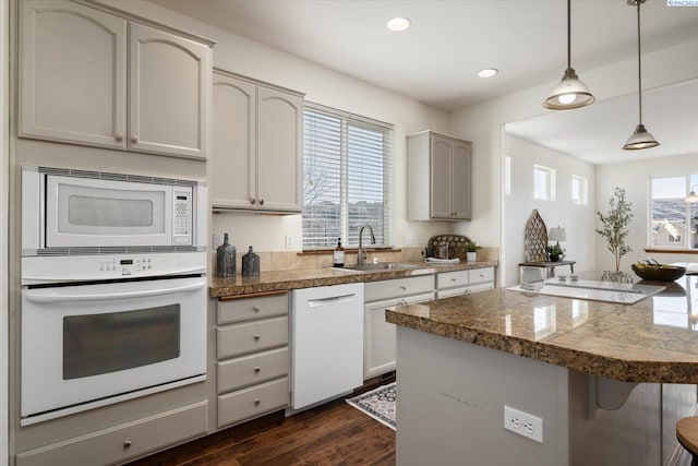 kitchen with white appliances, a sink, tile countertops, and a kitchen breakfast bar