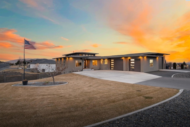 view of front of home with a garage and a lawn