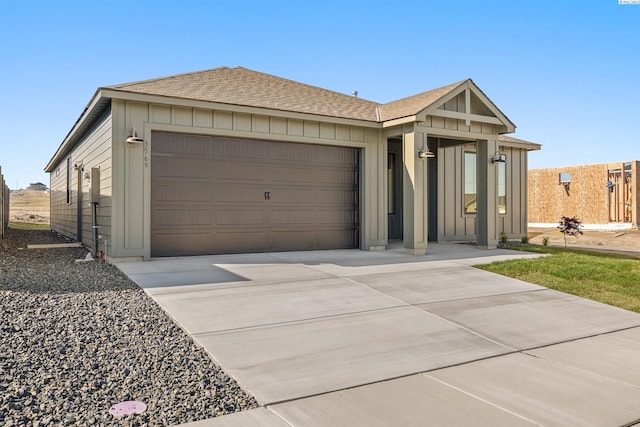 ranch-style home featuring an attached garage, driveway, roof with shingles, and board and batten siding