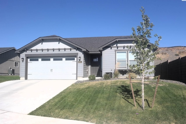 view of front of home with a garage, a front lawn, and central air condition unit