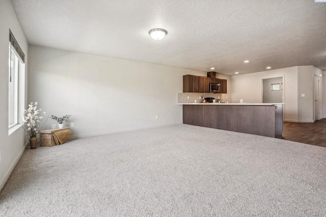 407 Dawson Ln, Pasco, WA 99301 - unfurnished living room featuring dark carpet, baseboards, recessed lighting, plenty of natural light, and a textured ceiling