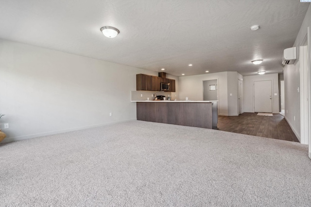 407 Dawson Ln, Pasco, WA 99301 - unfurnished living room featuring dark carpet, baseboards, recessed lighting, a wall unit AC, and a textured ceiling