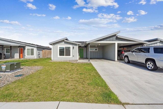 407 Dawson Ln, Pasco, WA 99301 - mid-century home with board and batten siding, an attached carport, and concrete driveway