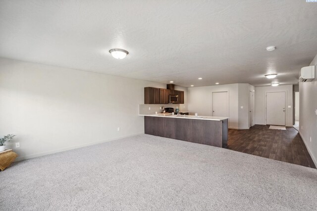 407 Dawson Ln, Pasco, WA 99301 - unfurnished living room featuring dark colored carpet, baseboards, a wall mounted AC, recessed lighting, and a textured ceiling