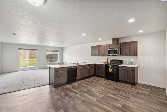 407 Dawson Ln, Pasco, WA 99301 - kitchen featuring black appliances, light countertops, a peninsula, open floor plan, and dark wood-style flooring