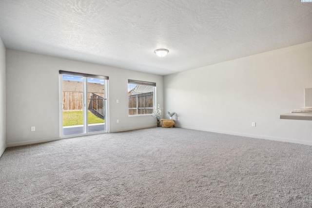 407 Dawson Ln, Pasco, WA 99301 - unfurnished living room featuring baseboards, carpet floors, and a textured ceiling
