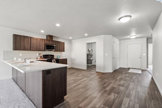 407 Dawson Ln, Pasco, WA 99301 - kitchen with stainless steel microwave, black range with electric cooktop, baseboards, wood finished floors, and a textured ceiling