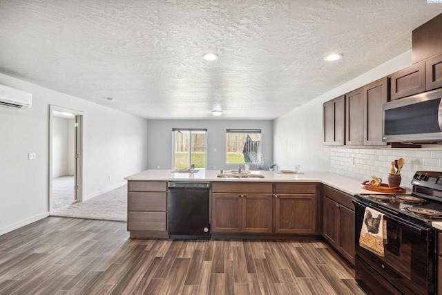 407 Dawson Ln, Pasco, WA 99301 - kitchen with black appliances, a peninsula, dark wood-type flooring, a sink, and a textured ceiling