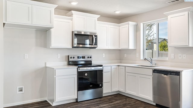 656 S Zeelar St, Kennewick, WA 99336 - kitchen featuring appliances with stainless steel finishes, a sink, dark wood-type flooring, white cabinets, and recessed lighting