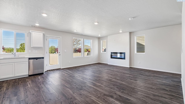656 S Zeelar St, Kennewick, WA 99336 - unfurnished living room with dark wood-style floors, baseboards, recessed lighting, a sink, and a glass covered fireplace