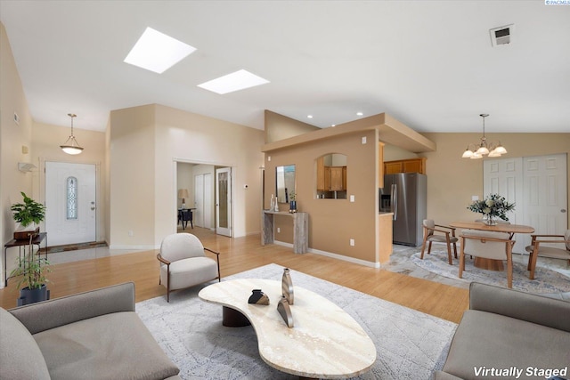 2704 Iris St, West Richland, WA 99353 - living area featuring light wood finished floors, a chandelier, baseboards, vaulted ceiling, and recessed lighting