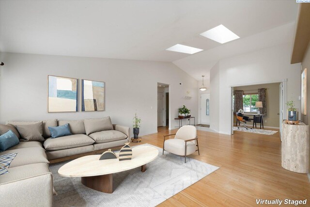 2704 Iris St, West Richland, WA 99353 - living room featuring a skylight, vaulted ceiling, and light wood-style floors