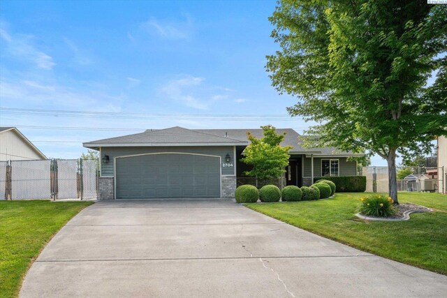 2704 Iris St, West Richland, WA 99353 - single story home with concrete driveway and an attached garage