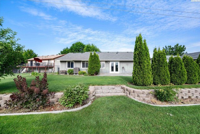 2704 Iris St, West Richland, WA 99353 - back of house featuring a yard, french doors, board and batten siding, and central AC unit