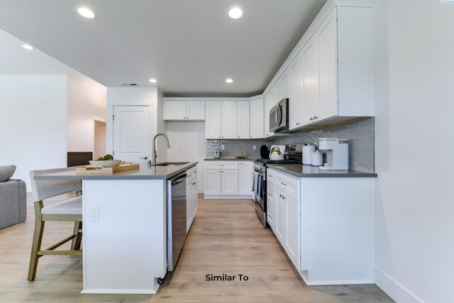 2945 S Penn St, Kennewick, WA 99338 - kitchen featuring stainless steel appliances, a sink, dark countertops, tasteful backsplash, and white cabinets