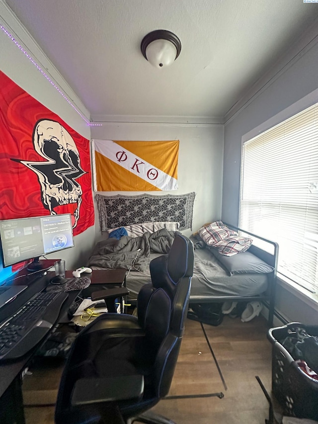 bedroom with hardwood / wood-style floors and crown molding