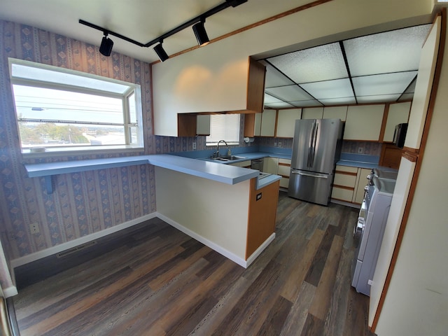 kitchen featuring dark hardwood / wood-style floors, stainless steel refrigerator, sink, stove, and kitchen peninsula