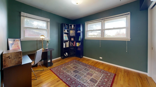 home office featuring baseboards, wood finished floors, and plenty of natural light