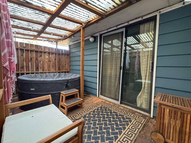 exterior space with fence, a pergola, and a hot tub