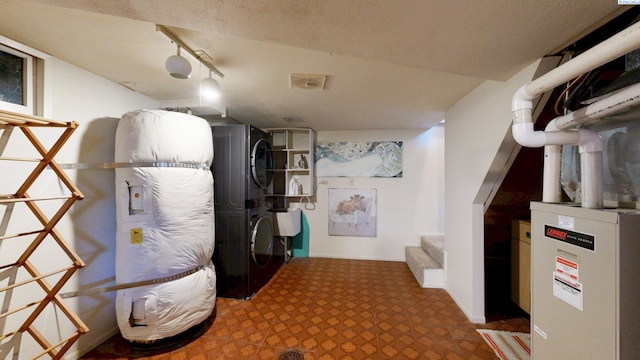 finished below grade area with stairs, stacked washer and clothes dryer, and carpet