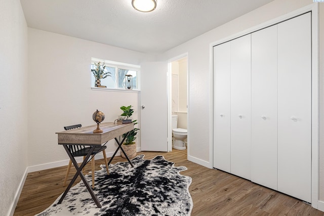 home office featuring hardwood / wood-style flooring and a textured ceiling