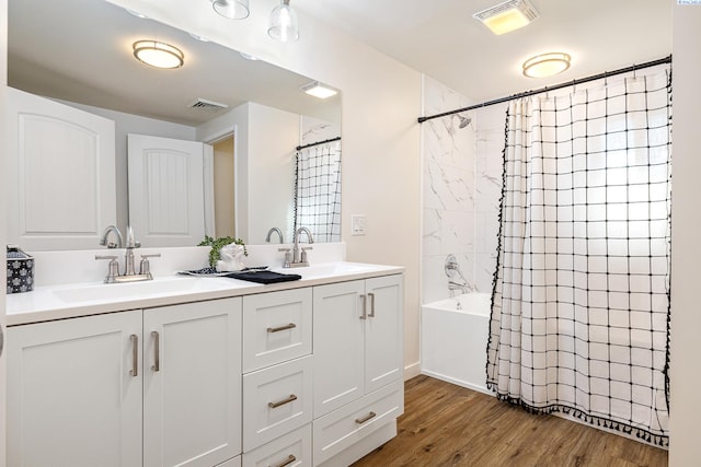 bathroom with hardwood / wood-style flooring, vanity, and shower / bath combo with shower curtain