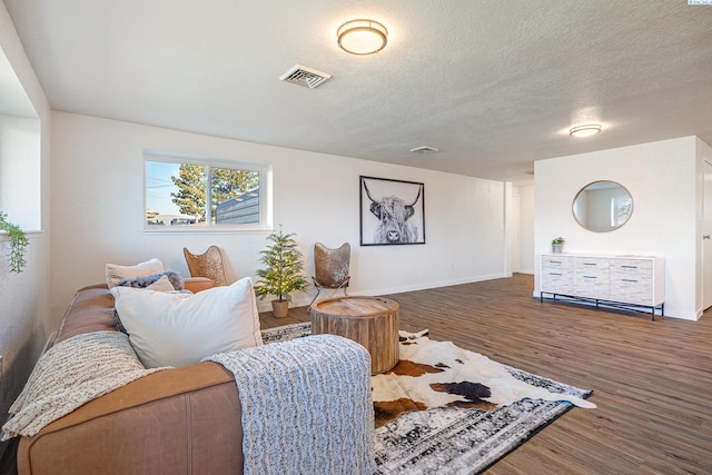 living room with dark wood-type flooring and a textured ceiling