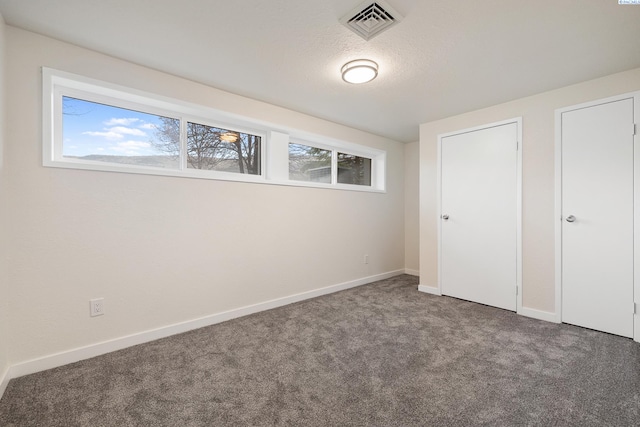 unfurnished bedroom with carpet floors and a textured ceiling