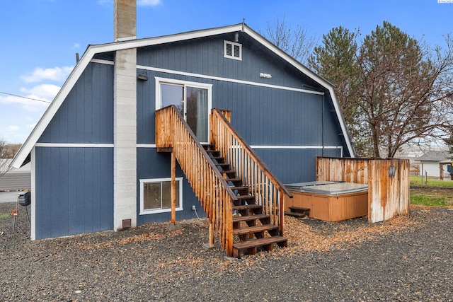 rear view of house featuring a hot tub