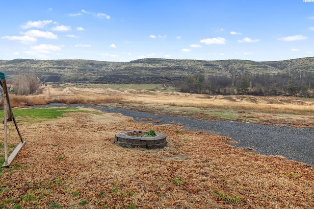 view of yard featuring a mountain view and an outdoor fire pit