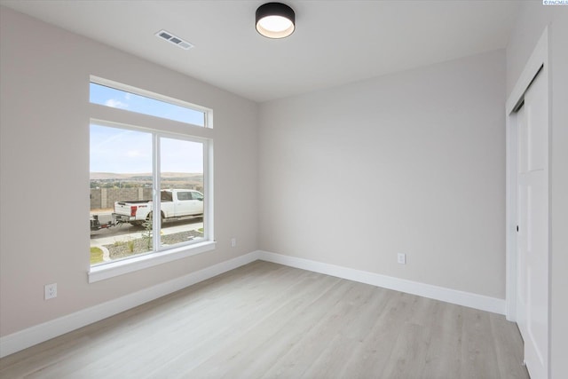 unfurnished bedroom featuring light hardwood / wood-style floors and a closet