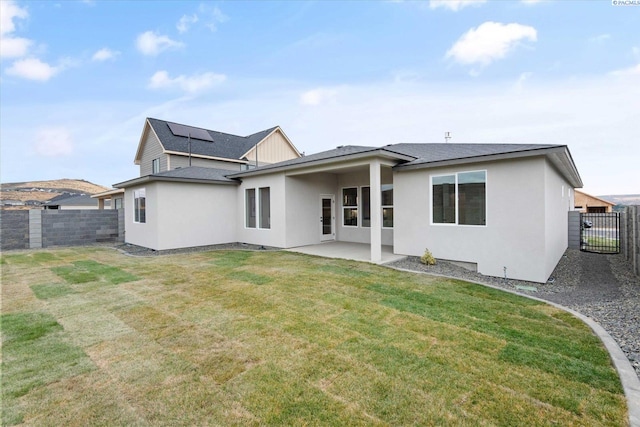 back of property featuring a patio and a lawn