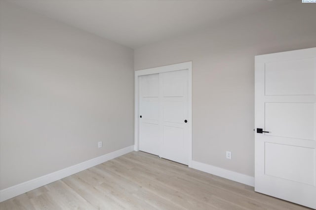 unfurnished bedroom with a closet and light wood-type flooring