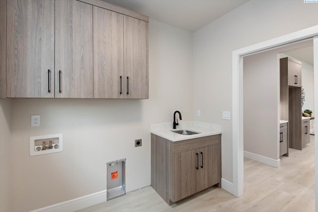 washroom featuring sink, cabinets, washer hookup, light hardwood / wood-style floors, and hookup for an electric dryer